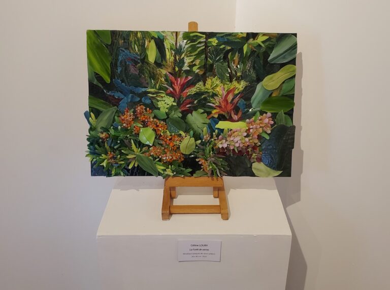 Tableau qui représente une forêt tropicale. C'est réalisé avec des plaques de verre. C'est une nature luxuriante qui est représentée. Oeuvre réalisée en mosaïque par Céline Loury