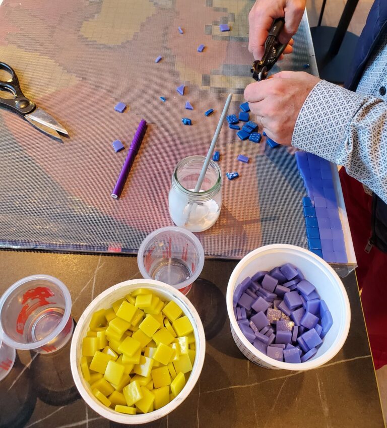 démarrage de l'activité mosaïque avec deux mains qui utilisent la pince pour découper quelques tesselles/