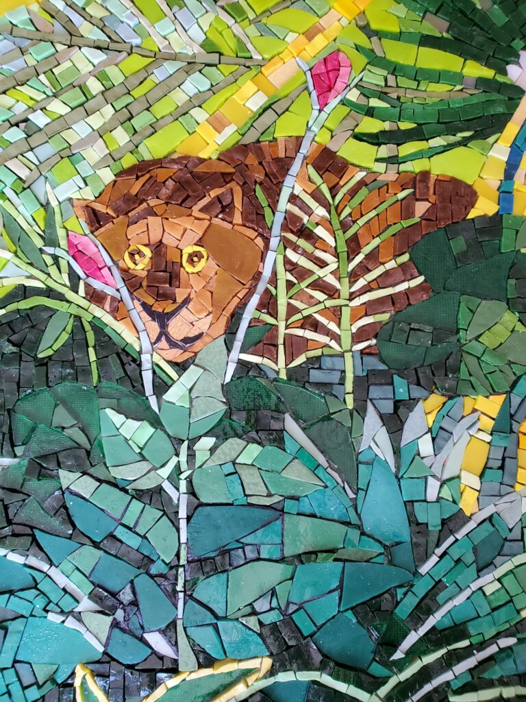détail d'une fresque en mosaïque avec une inspiration de l'oeuvre du Douanier Rousseau représentant une gentille lionne.
