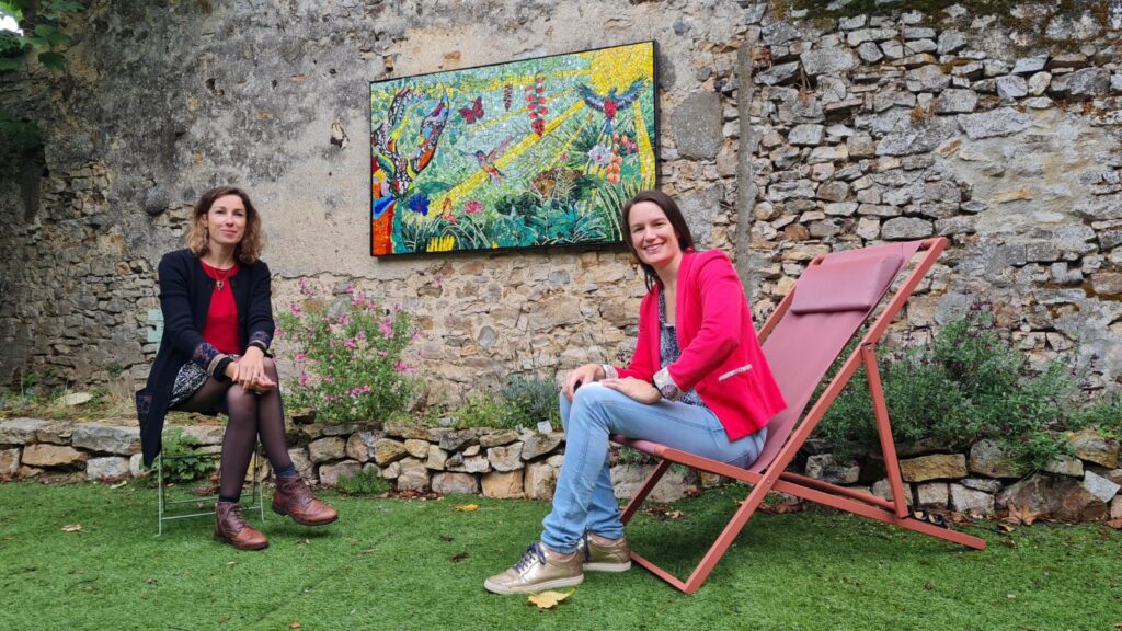 Fanny Guillo et Céline Loury, les deux créatrices de la fresque en mosaïque devant ce tableau coloré.