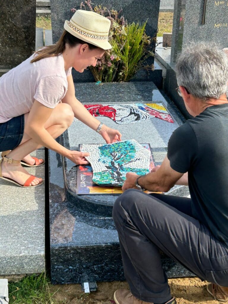 La mosaïste Céline Loury pose la mosaïque pour cette pierre tombale au cimetière de l'ouest du Mans