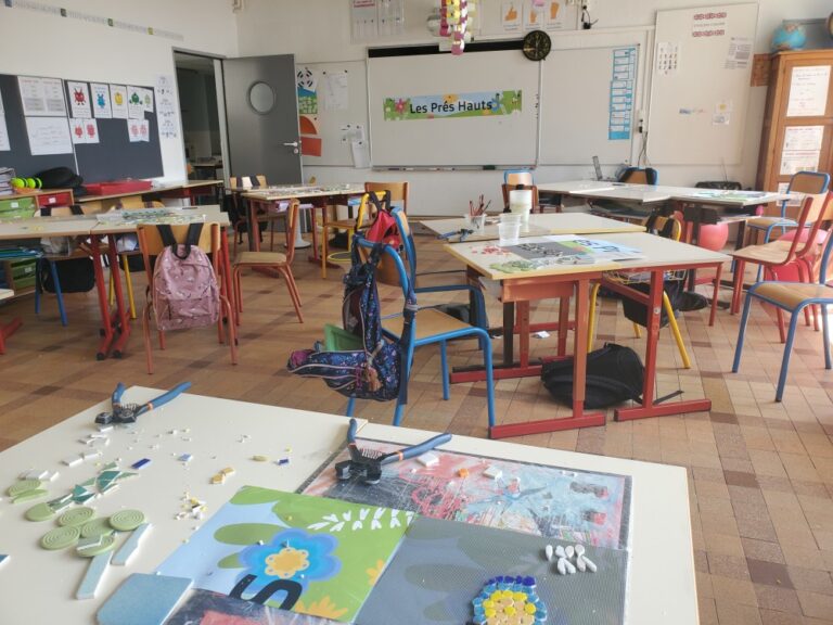vue de la classe lors de l'atelier mosaïque, il y a les tables des élèves et le modèle à réaliser dans le fond sur le tableau blanc