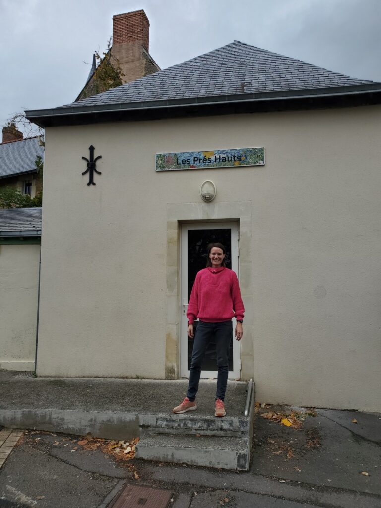Céline Loury au premier plan devant la fresque en mosaïque Les prés hauts