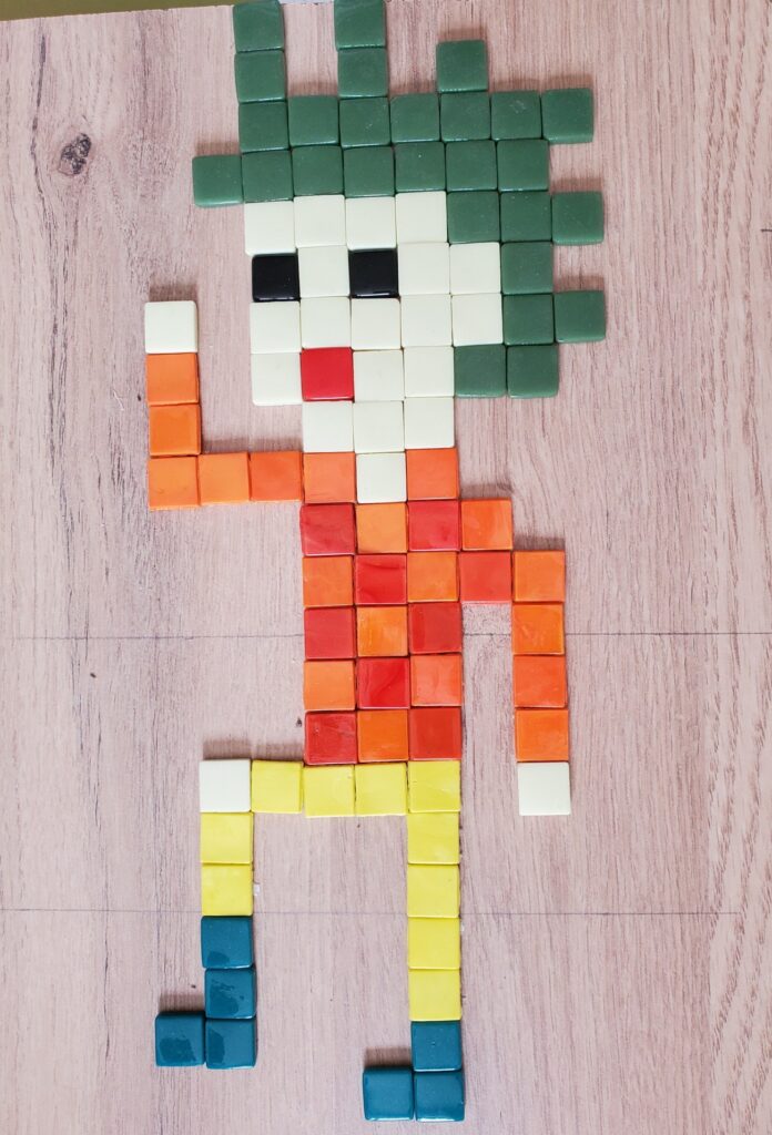 bonhomme avec un pantalon jaune, pull jacquard en rouge et orange, en mosaïque