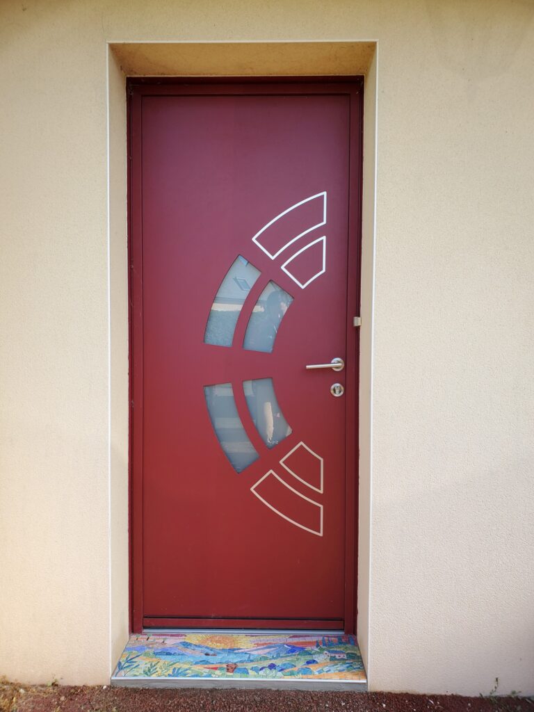 photo d'une porte rouge avec un seuil de porte en mosaïque réalisé par Céline Loury