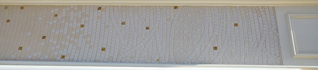 détail d'une mosaïque d'une enseigne en mosaïque, il s'agit d'une fève de cacao en blanc sur blanc avec un joint beige, réalisé par Céline Loury