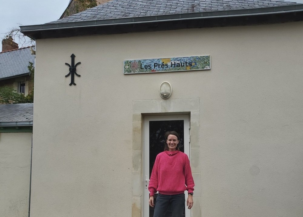 Céline Loury devant la fresque réalisée avec les élèves de l'école maternelle et primaire de Juigné-sur-Sarthe