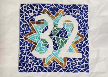 numéro de maison 32 de couleur blanche devant un motif de type étoile en bleu turquoise