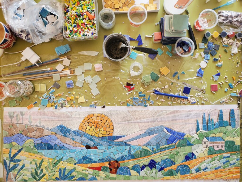 plan de travail d'un atelier de mosaïque avec la réalisation en cours d'un paysage par Céline Loury
