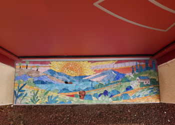 vue avec la porte et le seuil d'entrée en mosaïque vue de dessus, c'est un paysage en émaux de Briare, très coloté avec les montagnes et le soleil, réalisé par Céline Loury