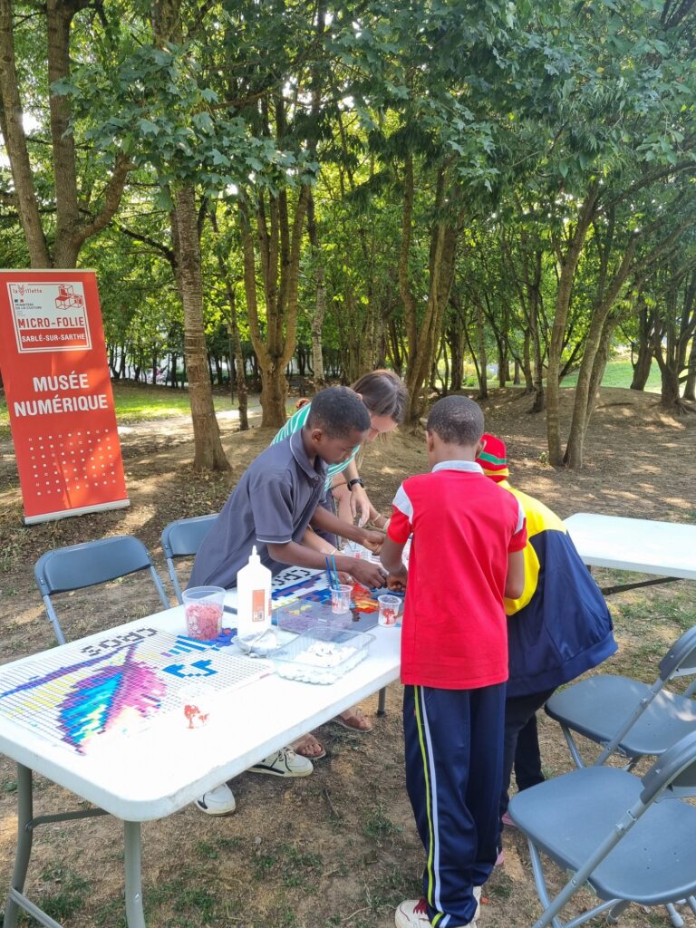 Atelier mosaïque dans le quartier Montreux à Sablé sur Sarthe - une table avec trois personnes qui créent une mosaïque avec Céline Loury de Sablé sur Sarthe