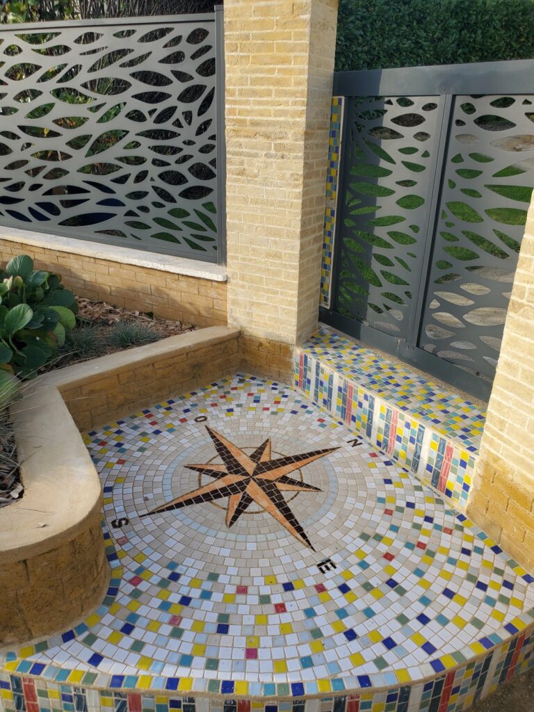 vue d'une mosaïque posée avant le portail gris de l'entrée de la maison