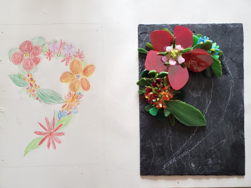 Sur l'image, il y a à gauche le dessin d'un numéro neuf avec des fleurs de toutes les couleurs et à côté, à droite de l'image, il y a le numéro 9 commencé en mosaïque par Céline Loury